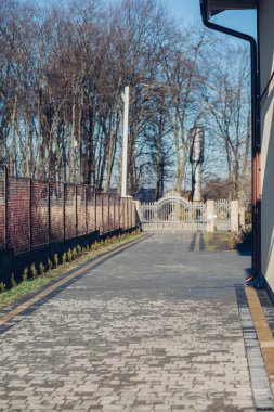 Demir kapılar ve yol kenarındaki çitler kaldırım levhalarından.