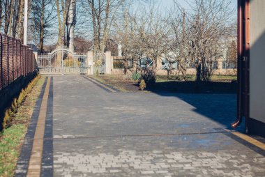 Demir kapılar ve yol kenarındaki çitler kaldırım levhalarından.