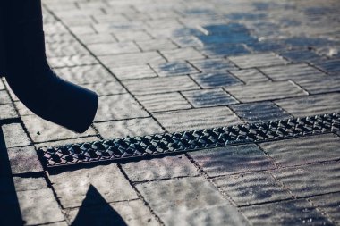 Kenardan gelen suyla yağmur oluğu aşağı akıyor. Taş kiremitlerin etrafında