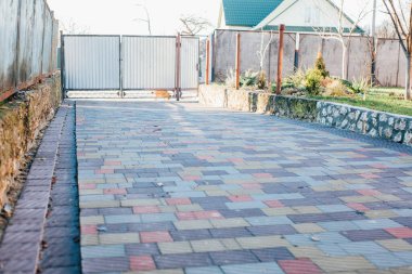 Demir kapılar ve yol kenarındaki çitler kaldırım levhalarından.