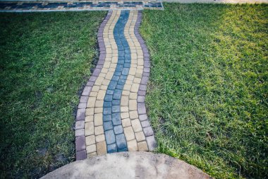 Yeşil bitkilerle dolu bahçe taşı patikası, gündüz vakti tuğla kaldırım. 