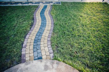 Yeşil bitkilerle dolu bahçe taşı patikası, gündüz vakti tuğla kaldırım. 