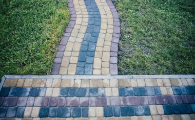 Yeşil bitkilerle dolu bahçe taşı patikası, gündüz vakti tuğla kaldırım. 