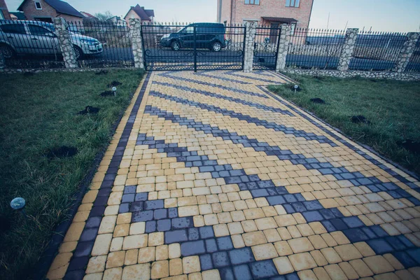 Demir kapılar ve yol kenarındaki çitler kaldırım levhalarından.