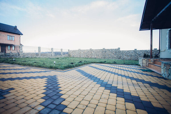 Садовая каменная дорожка с зелеными растениями, кирпичный тротуар в дневное время 