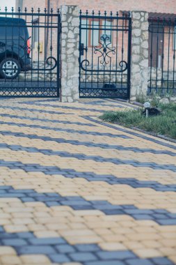 Demir kapılar ve yol kenarındaki çitler kaldırım levhalarından.