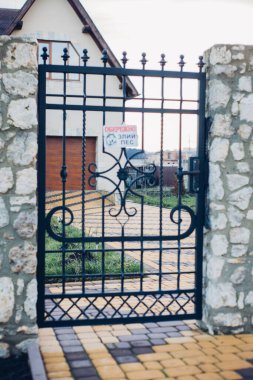 Demir kapılar ve yol kenarındaki çitler kaldırım levhalarından.