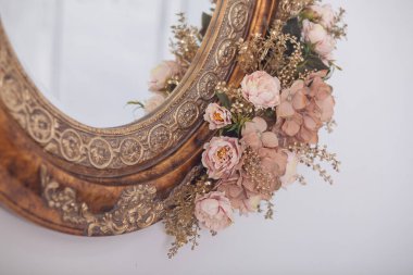 Çerçevede eski aynada pembe çiçekler, stüdyo dekorasyonu.