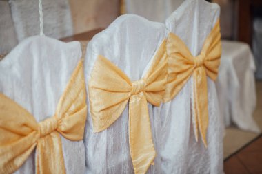 Restoranda sandalyede fiyonklar