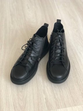 Ahşap arka planda siyah deri erkek ayakkabıları.