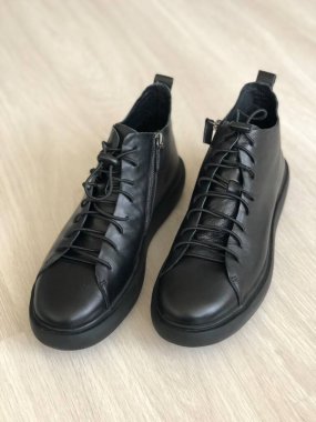 Ahşap arka planda siyah deri erkek ayakkabıları.