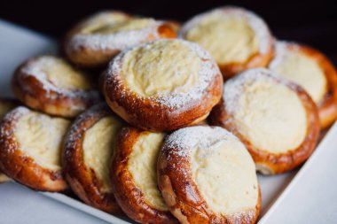 Beyaz masa arkaplanındaki bir tabakta süzme peynirli çörek.