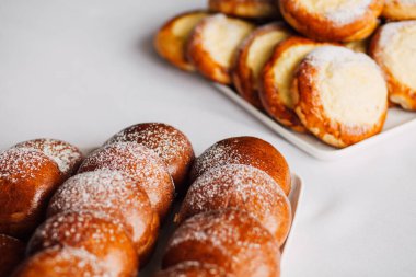 Beyaz masa arkaplanındaki bir tabakta süzme peynirli çörek.