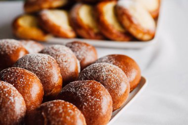 Beyaz masa arkaplanındaki bir tabakta süzme peynirli çörek.