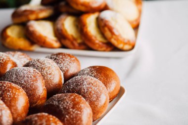 Beyaz masa arkaplanındaki bir tabakta süzme peynirli çörek.