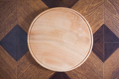 Round wooden board on wooden background