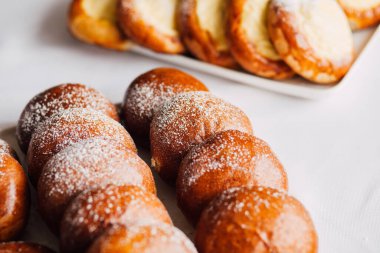 Beyaz masa arkaplanındaki bir tabakta süzme peynirli çörek.
