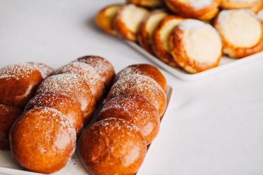 Beyaz masa arkaplanındaki bir tabakta süzme peynirli çörek.