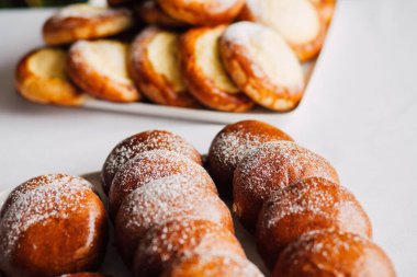 Beyaz masa arkaplanındaki bir tabakta süzme peynirli çörek.