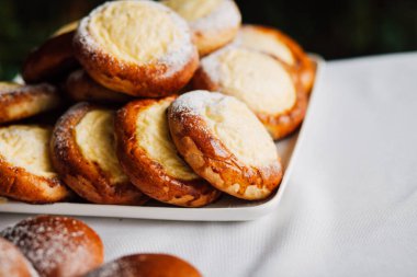 Beyaz masa arkaplanındaki bir tabakta süzme peynirli çörek.