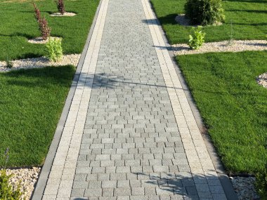 Yeşil bitkilerle dolu bahçe taşı patikası, gündüz vakti tuğla kaldırım. 