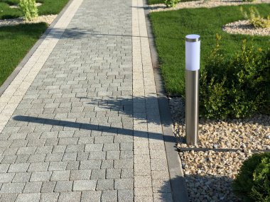 Yeşil bitkilerle dolu bahçe taşı patikası, gündüz vakti tuğla kaldırım. 