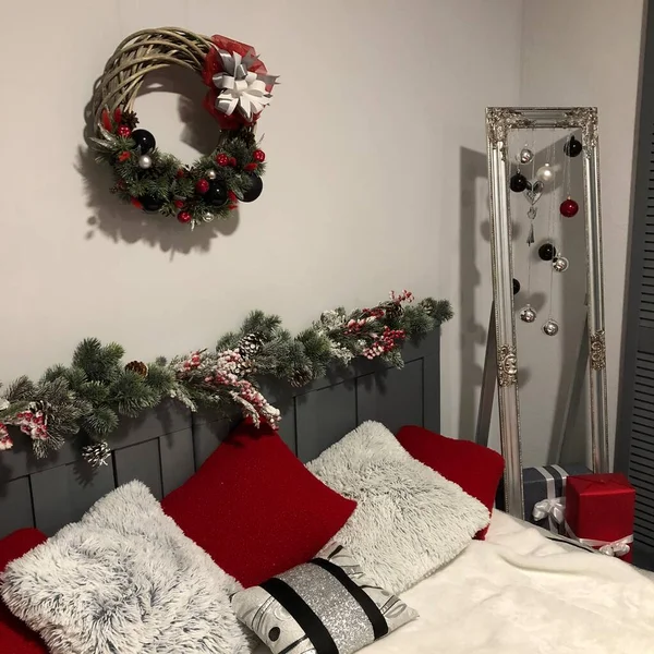 Bedroom decorated by Christmas. Cozy light interior, New Year's fir-tree decorated with toys and garlands