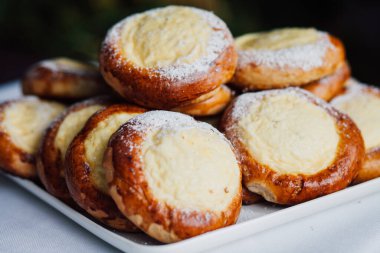 Beyaz masa arkaplanındaki bir tabakta süzme peynirli çörek.