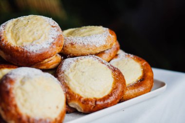 Beyaz masa arkaplanındaki bir tabakta süzme peynirli çörek.