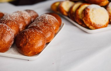 Beyaz masa arkaplanındaki bir tabakta süzme peynirli çörek.