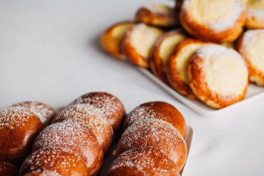 Beyaz masa arkaplanındaki bir tabakta süzme peynirli çörek.