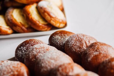 Beyaz masa arkaplanındaki bir tabakta süzme peynirli çörek.