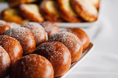 Beyaz masa arkaplanındaki bir tabakta süzme peynirli çörek.