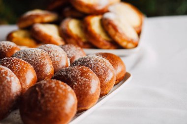 Beyaz masa arkaplanındaki bir tabakta süzme peynirli çörek.
