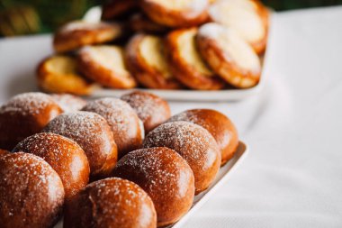 Beyaz masa arkaplanındaki bir tabakta süzme peynirli çörek.