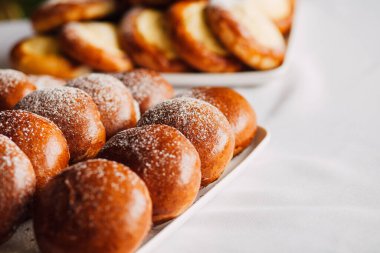 Beyaz masa arkaplanındaki bir tabakta süzme peynirli çörek.