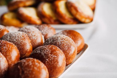 Beyaz masa arkaplanındaki bir tabakta süzme peynirli çörek.
