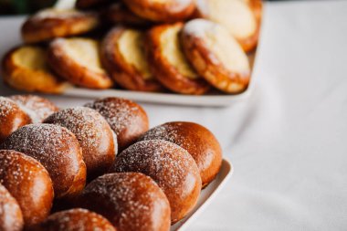 Beyaz masa arkaplanındaki bir tabakta süzme peynirli çörek.