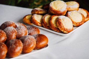 Beyaz masa arkaplanındaki bir tabakta süzme peynirli çörek.