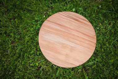 Yeşil çim arka planda yuvarlak ahşap tahta