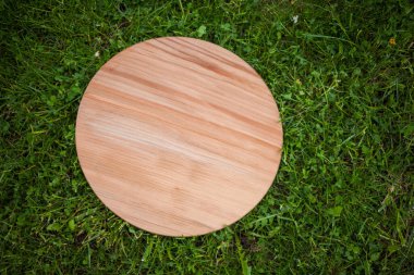 Yeşil çim arka planda yuvarlak ahşap tahta