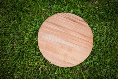 Yeşil çim arka planda yuvarlak ahşap tahta