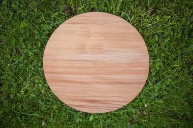Yeşil çim arka planda yuvarlak ahşap tahta
