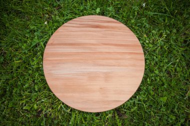 Yeşil çim arka planda yuvarlak ahşap tahta
