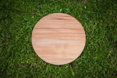 Yeşil çim arka planda yuvarlak ahşap tahta
