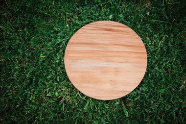 Yeşil çim arka planda yuvarlak ahşap tahta