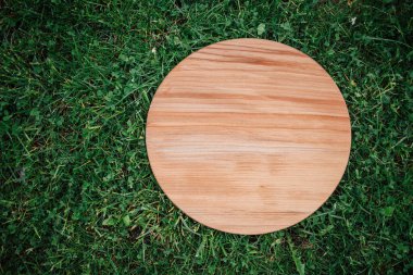 Yeşil çim arka planda yuvarlak ahşap tahta
