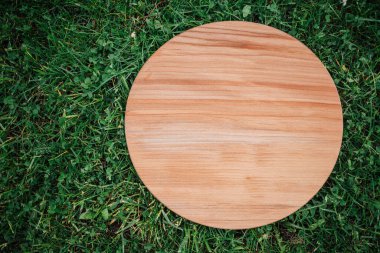 Yeşil çim arka planda yuvarlak ahşap tahta