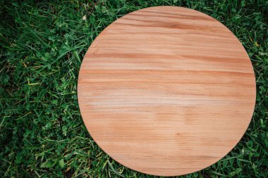 Yeşil çim arka planda yuvarlak ahşap tahta