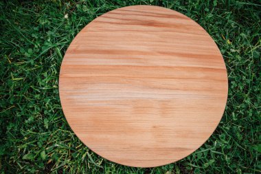 Yeşil çim arka planda yuvarlak ahşap tahta